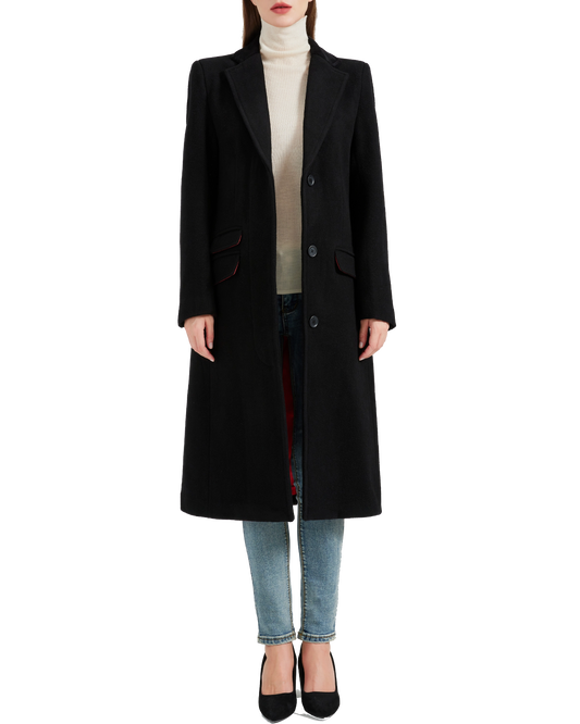 Front view of the women's black covert overcoat buttoned over a cream roll-neck and jeans