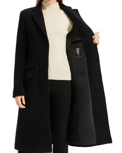Model holding the black covert overcoat open at the lapel