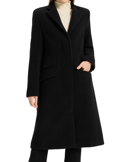 Model with one hand in the pocket of the black covert overcoat